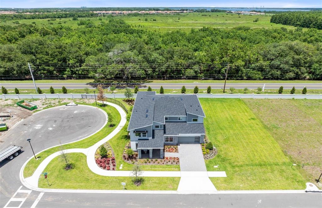 An aerial view shows a modern two-story house with a gray exterior and asphalt roof — 11205 CHANNELSIDE LANE, ORLANDO, FL