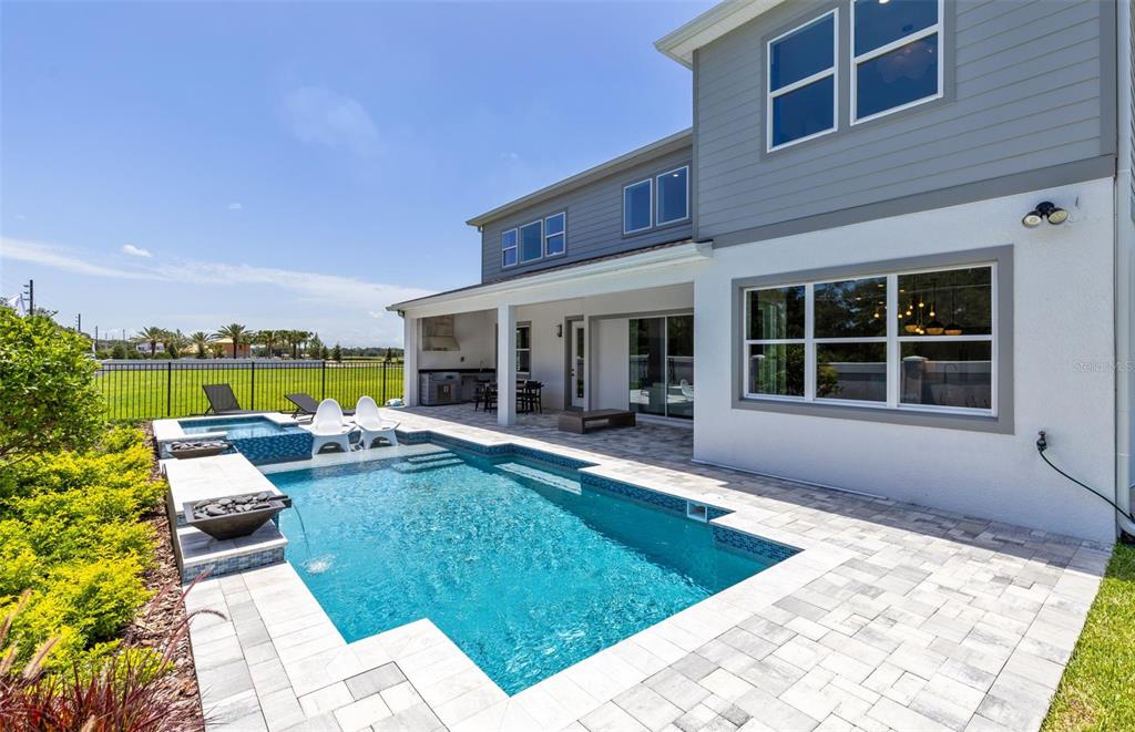A two-story house exterior features a swimming pool, spa, and covered patio area — 11205 CHANNELSIDE LANE, ORLANDO, FL