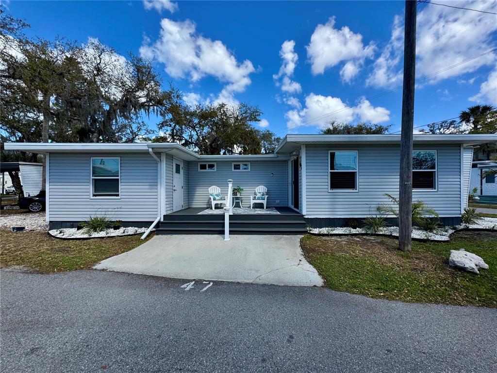 A light blue single-story house with a small front deck and a concrete driveway — 15010 113TH AVENUE N UNIT 47, LARGO, FL