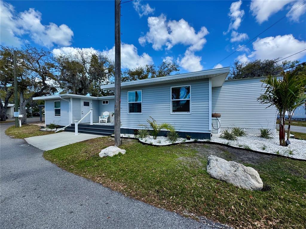 A light blue single-story house with white trim and a small front porch — 15010 113TH AVENUE N UNIT 47, LARGO, FL