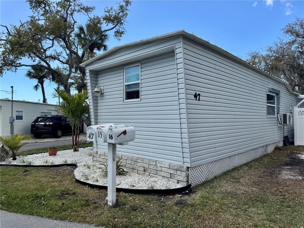 A light gray mobile home with a white stone base and a cluster of mailboxes — 15010 113TH AVENUE N UNIT 47, LARGO, FL