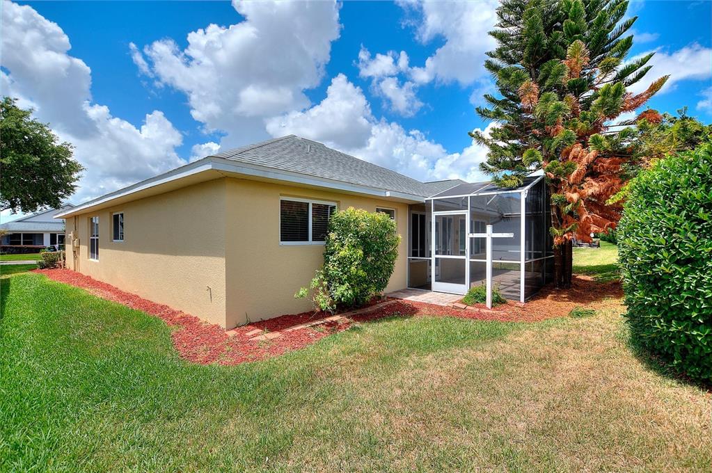 The exterior view shows a tan stucco house with a screened-in lanai and landscaping — 4130 BEDFORD AVENUE, WINTER HAVEN, FL