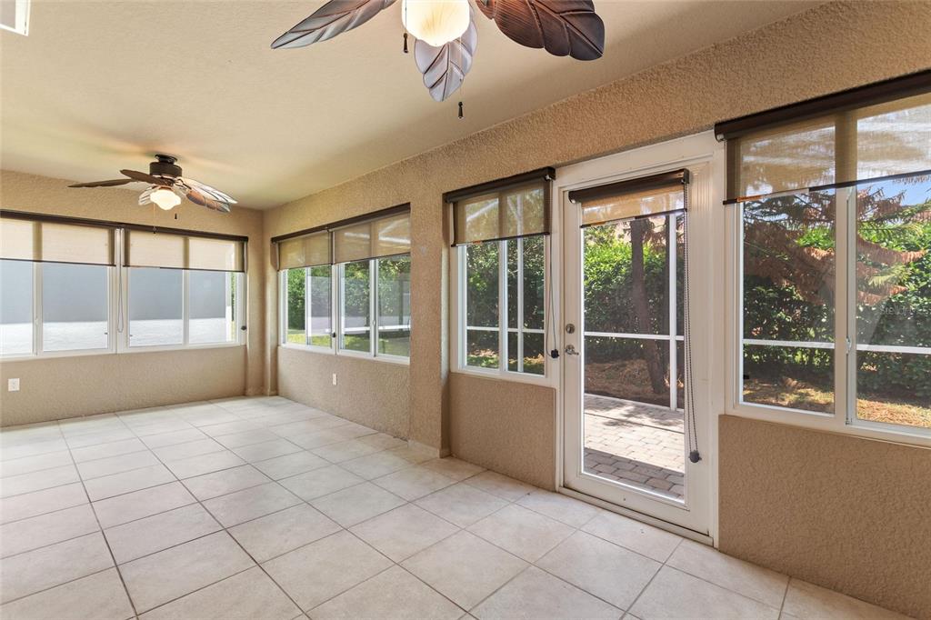 A sunroom features tiled floors, two ceiling fans, and multiple windows overlooking a patio area — 4130 BEDFORD AVENUE, WINTER HAVEN, FL