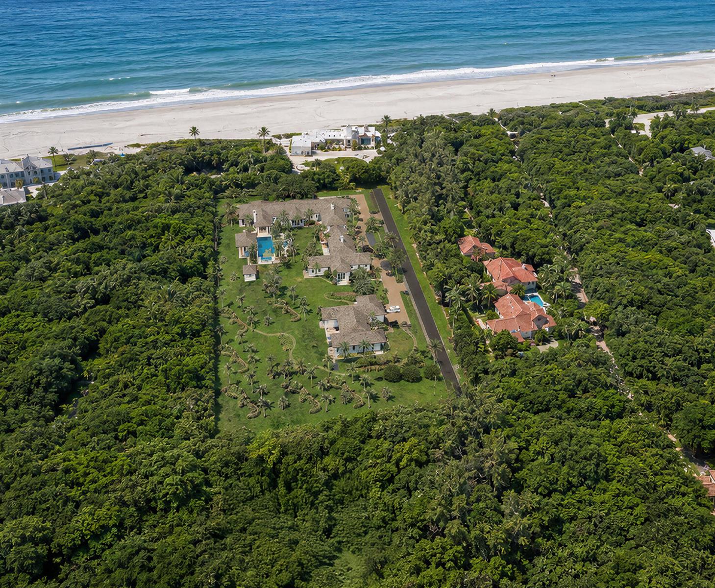 An aerial view shows a large estate with multiple buildings, pools, and lawns near the ocean — 302 S Beach Road, Jupiter Island FL 33455, JUPITER ISLAND, FL