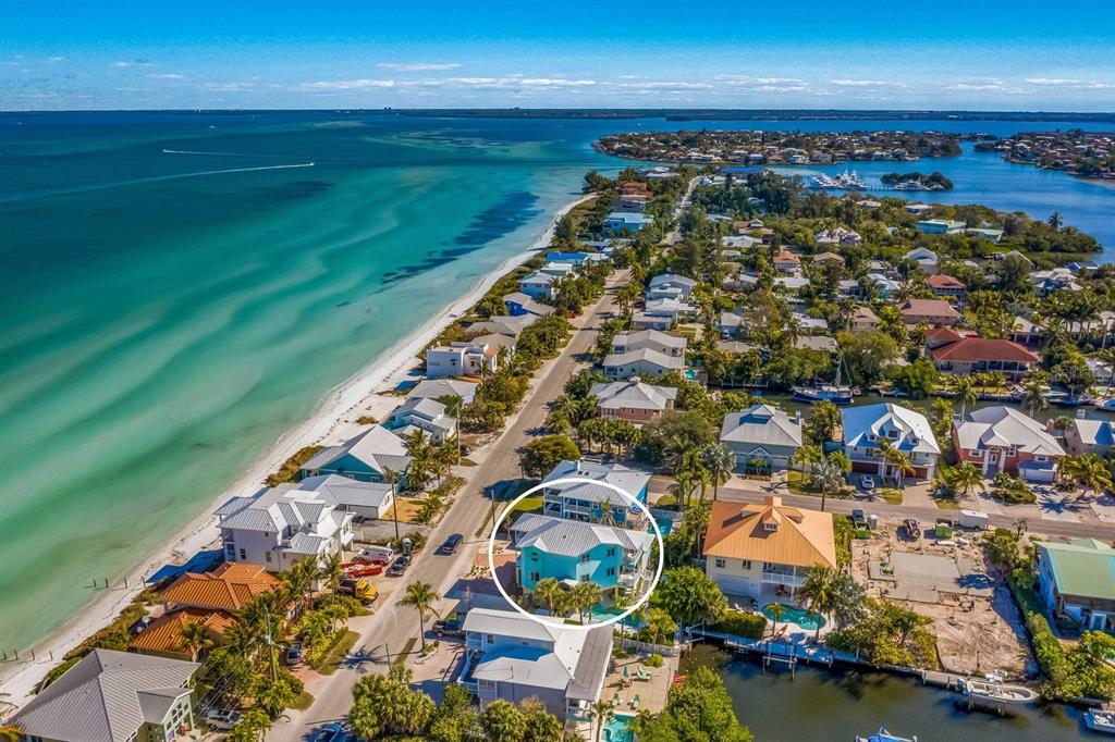 An aerial view of a coastal neighborhood featuring a light blue house circled in white — 505 S BAY BOULEVARD, ANNA MARIA, FL
