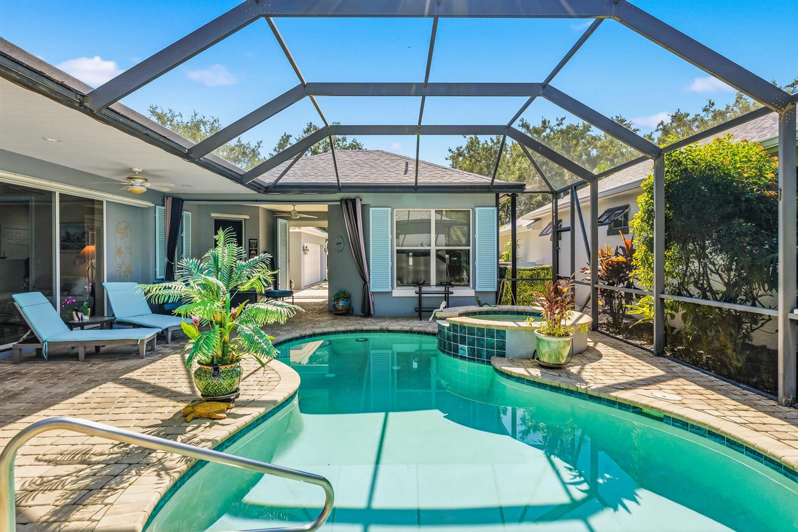 A screened-in patio features a swimming pool, a raised hot tub, and lounge chairs — 228 Oak Hammock Circle SW, Vero Beach FL 32962, VERO BEACH, FL