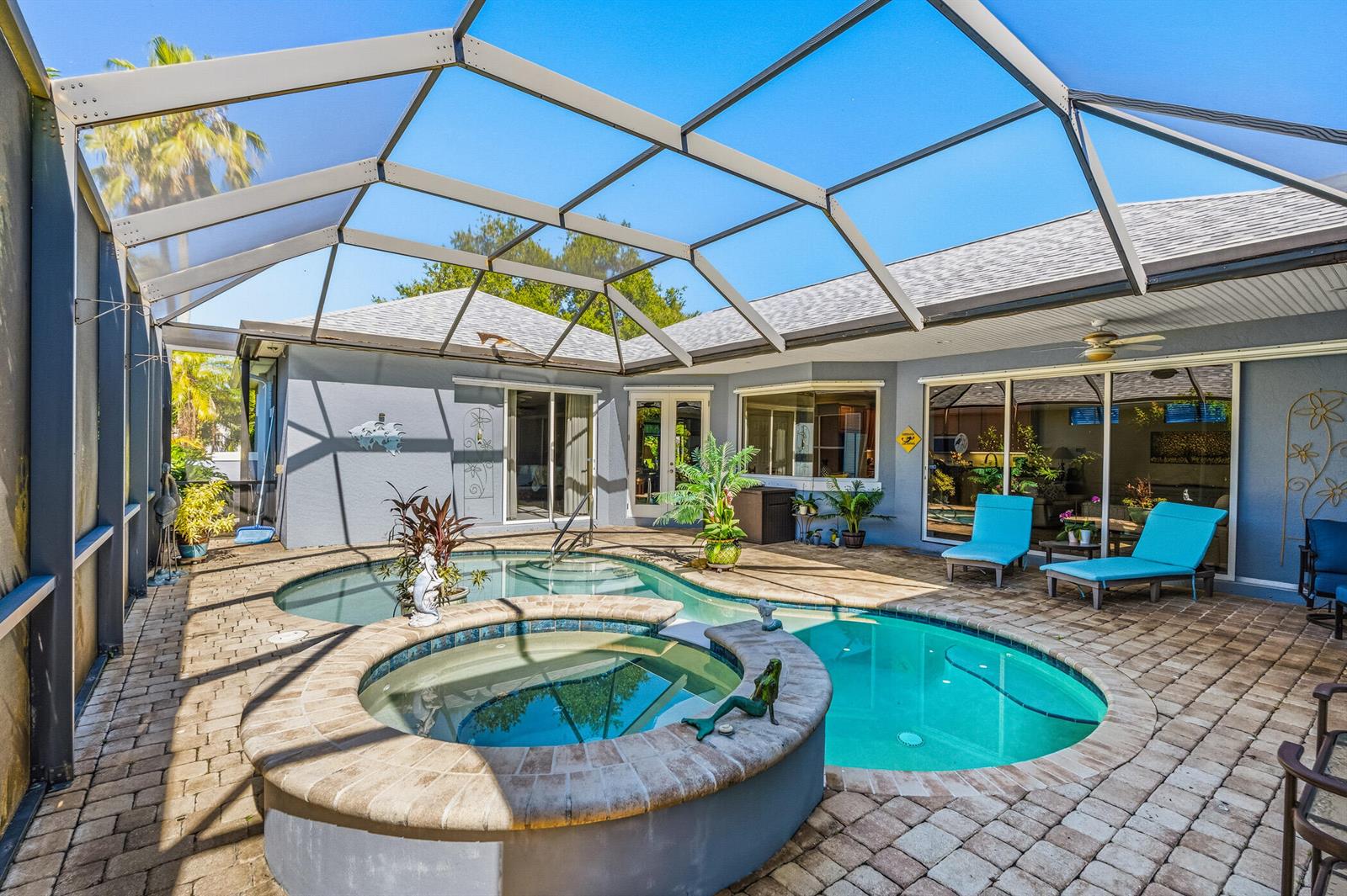 A screened-in patio features a swimming pool, a raised hot tub, and two lounge chairs — 228 Oak Hammock Circle SW, Vero Beach FL 32962, VERO BEACH, FL