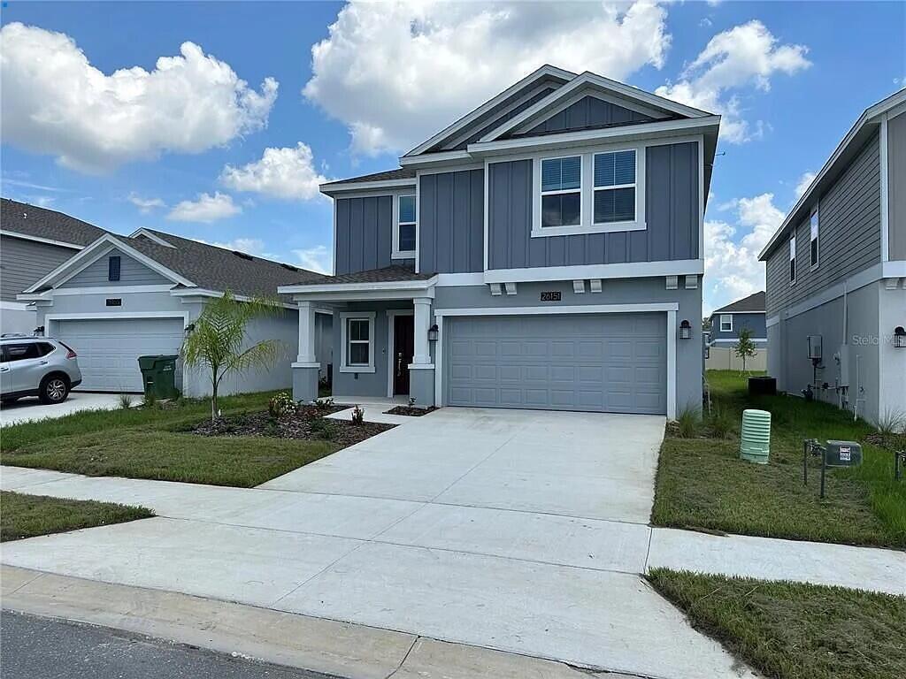 A two-story house with gray siding, a two-car garage, and a concrete driveway — 26151 Feathergrass Circle, FL 34748, FL
