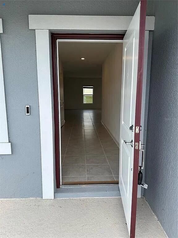 An open front door reveals a tiled entryway leading to a room with a window — 26151 Feathergrass Circle, FL 34748, FL