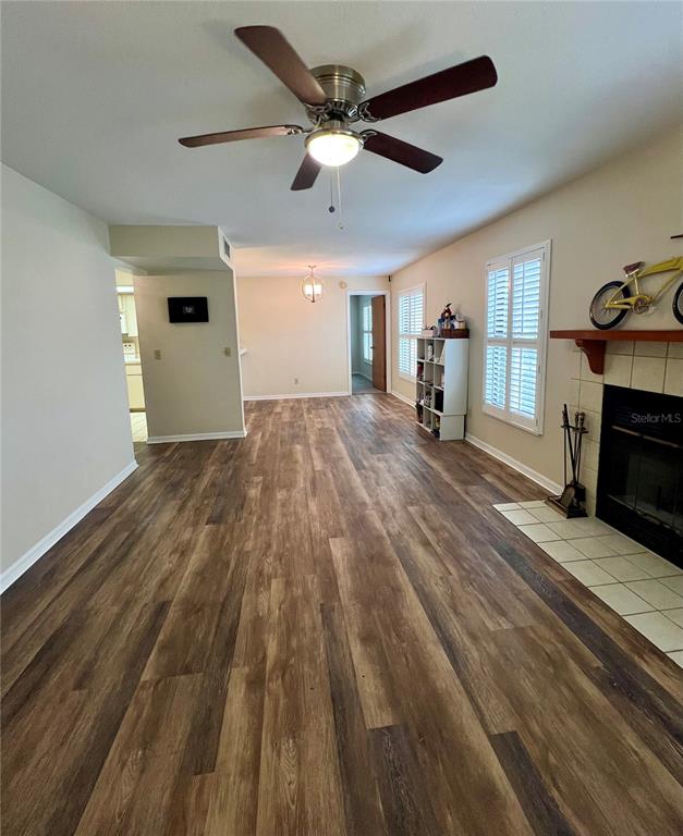 A living room features wood-look flooring, a ceiling fan, and a fireplace with a mantel — 2352 FOREST DRIVE UNIT 2352, INVERNESS, FL