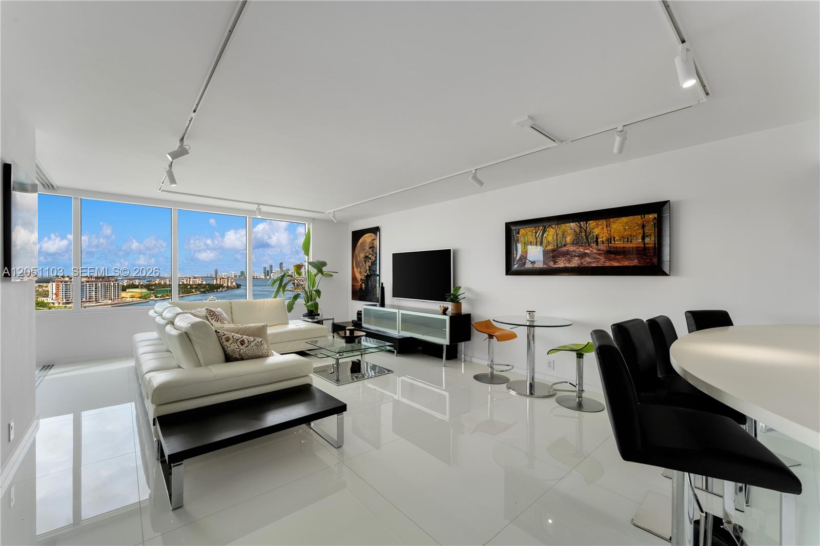 A modern living room with white tile floors, a white sectional sofa, and floor-to-ceiling windows — 400 S Pointe Dr # 1805, Miami Beach FL 33139, MIAMI BEACH, FL