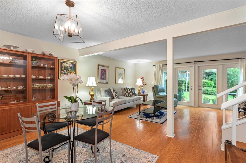 A dining area and living room with hardwood floors, a glass table, and glass doors — 283 W LAKE FAITH DRIVE UNIT 146, MAITLAND, FL