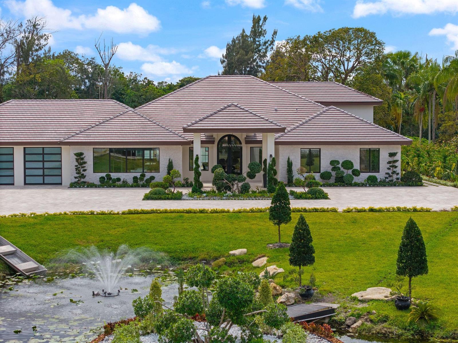 A single-story house with a tiled roof, stone facade, and a front yard with a fountain — 13110 Mustang Trail, Southwest Ranches FL 33330, SOUTHWEST RANCHES, FL