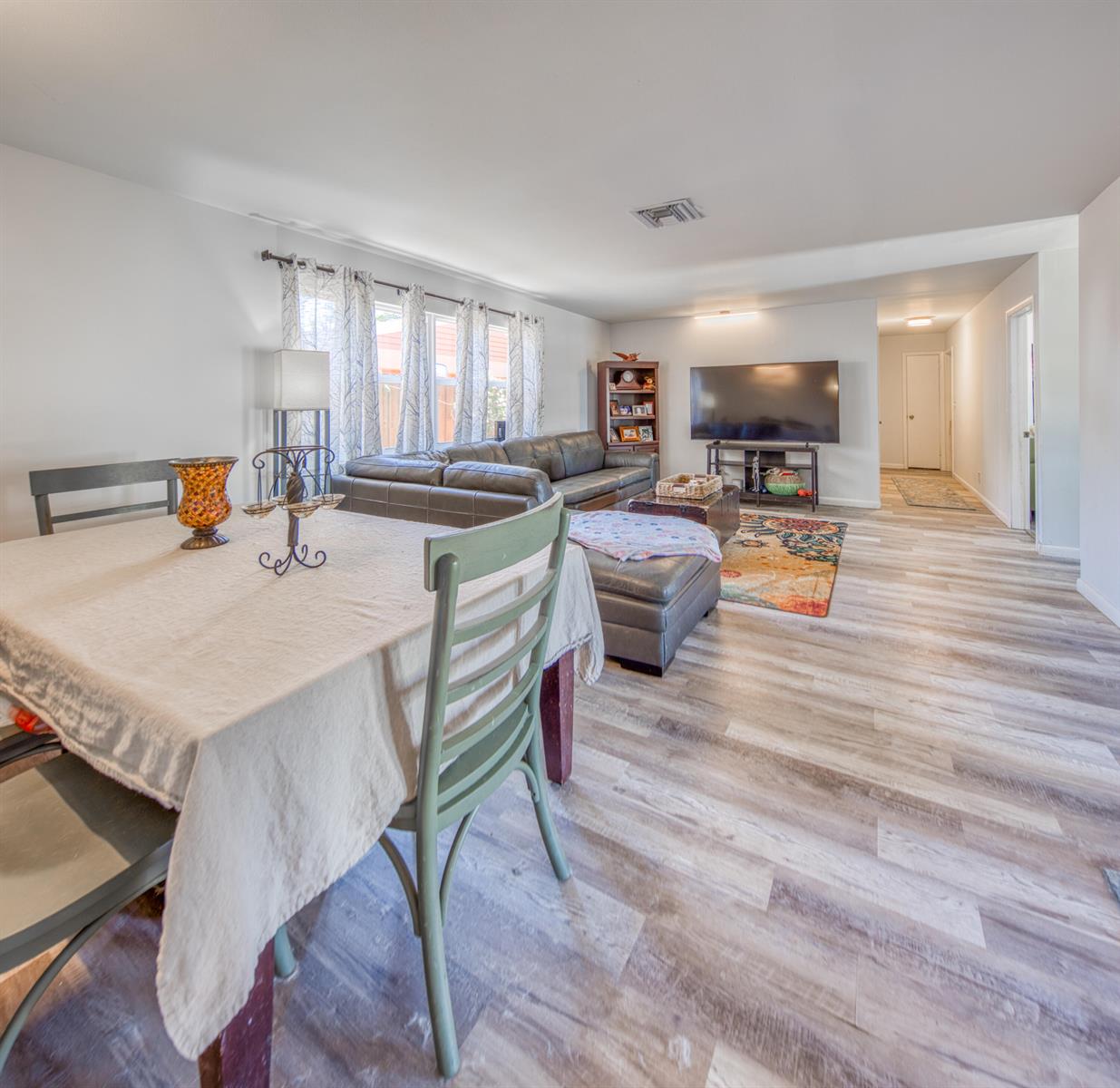 A kitchen features white cabinets, a wooden island, stainless steel appliances, and wood-look flooring — 1430 N N Street, FL 33460, FL
