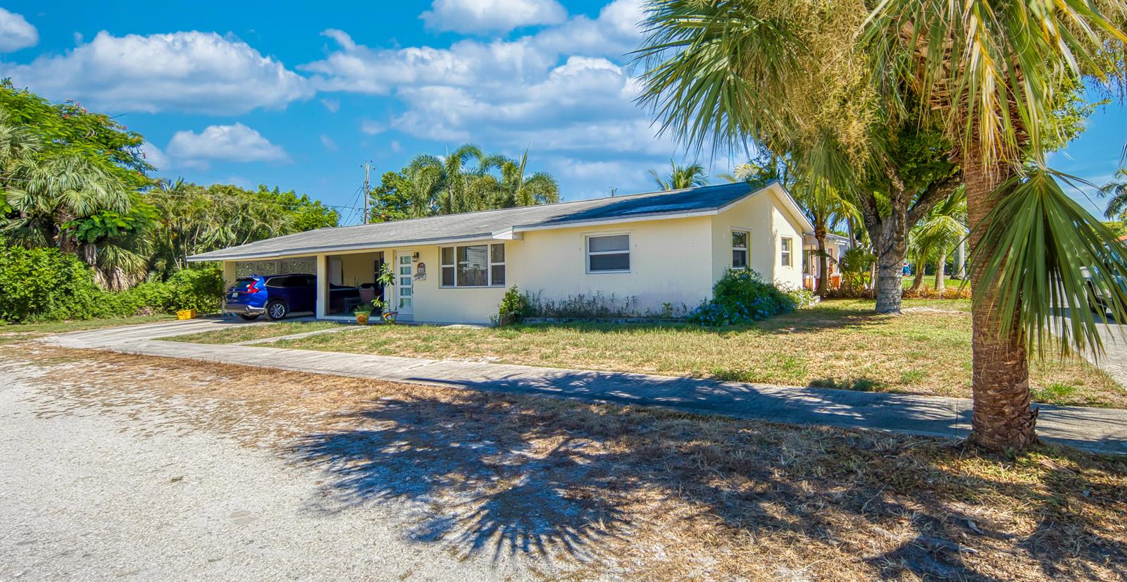An open-concept living and dining area features light wood-look flooring and a gray sectional sofa — 1430 N N Street, FL 33460, FL