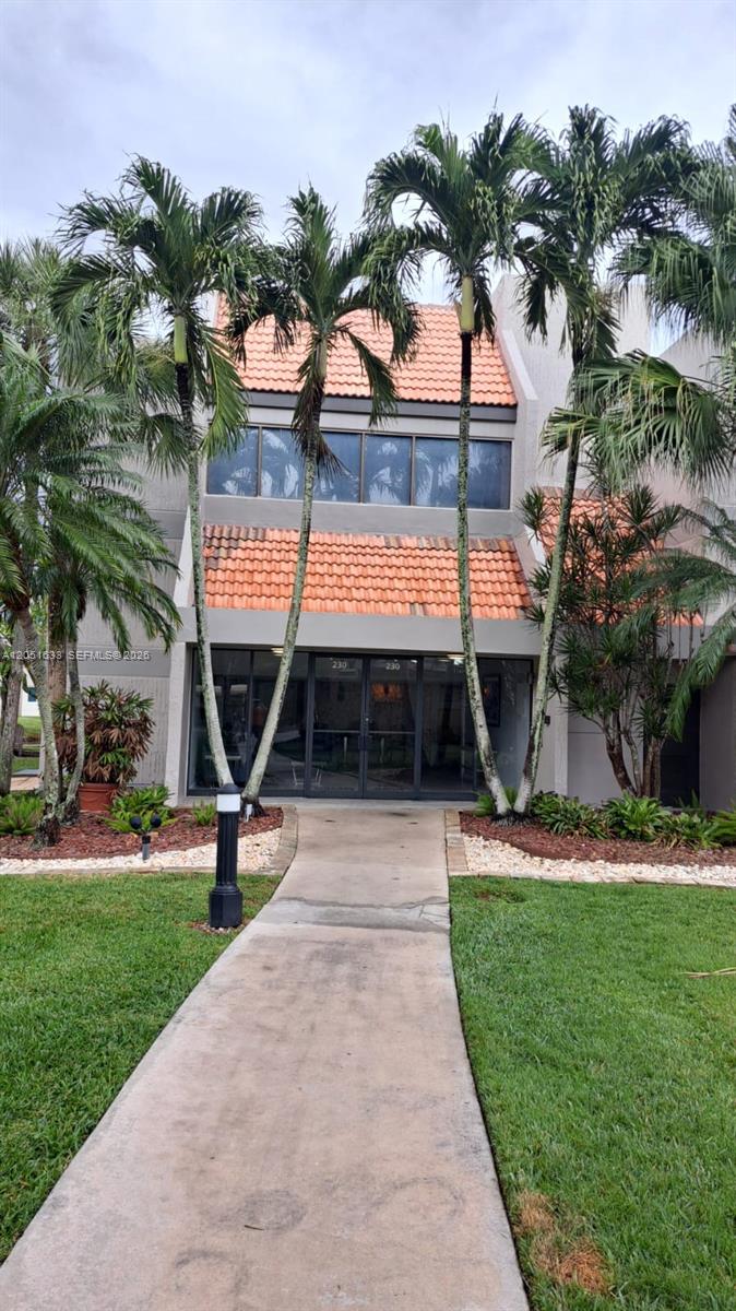 A concrete walkway leads to the entrance of a two-story building with orange roof tiles — 230 Lakeview Dr # 310, Weston FL 33326, WESTON, FL