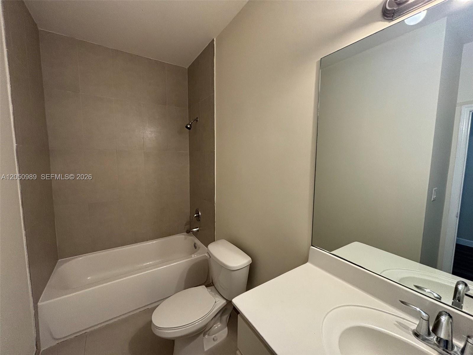 A bathroom features a white vanity, a toilet, and a bathtub with tiled walls — 10445 NW 61 LN # 10445, Doral FL 33178, DORAL, FL