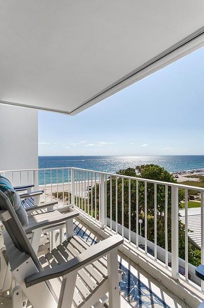 A balcony with white railings overlooks a sandy beach and the ocean — 1010 S Ocean Boulevard # 602, Pompano Beach FL 33062, POMPANO BEACH, FL