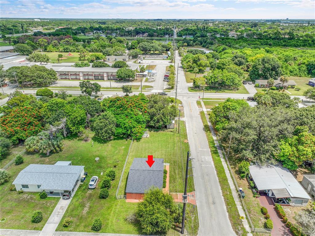 An aerial view shows a single-story house with a gray roof and a red arrow — 2102 AVENUE P, FORT PIERCE, FL