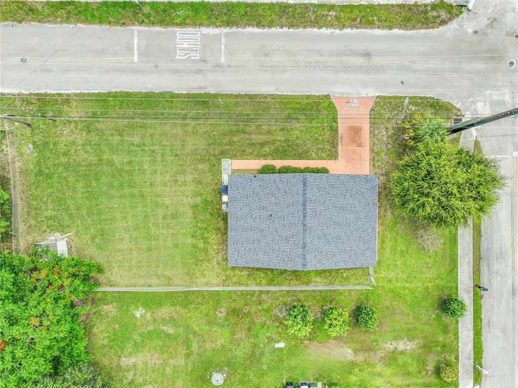 An aerial view shows a house with a gray roof, a lawn, and a paved driveway — 2102 AVENUE P, FORT PIERCE, FL