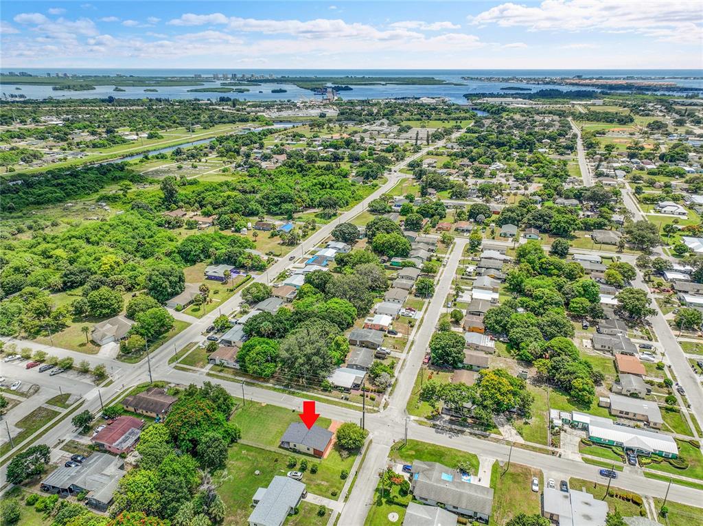 An aerial view shows a residential neighborhood with a red arrow pointing to a house — 2102 AVENUE P, FORT PIERCE, FL