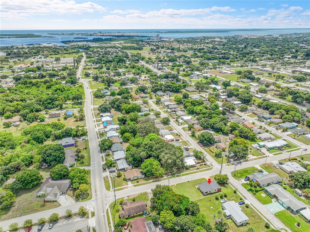 An aerial view shows a residential neighborhood with a red arrow pointing to a house — 2102 AVENUE P, FORT PIERCE, FL