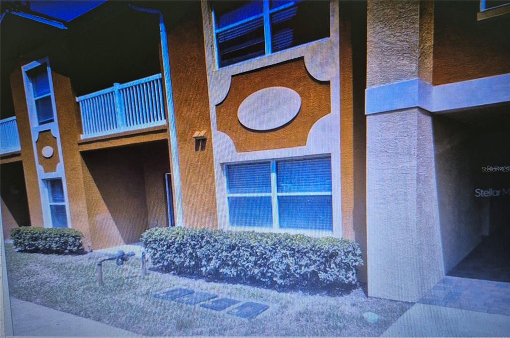 An exterior view of a two-story apartment building with stucco walls and a balcony — 4600 E MOODY BOULEVARD UNIT 8B, BUNNELL, FL