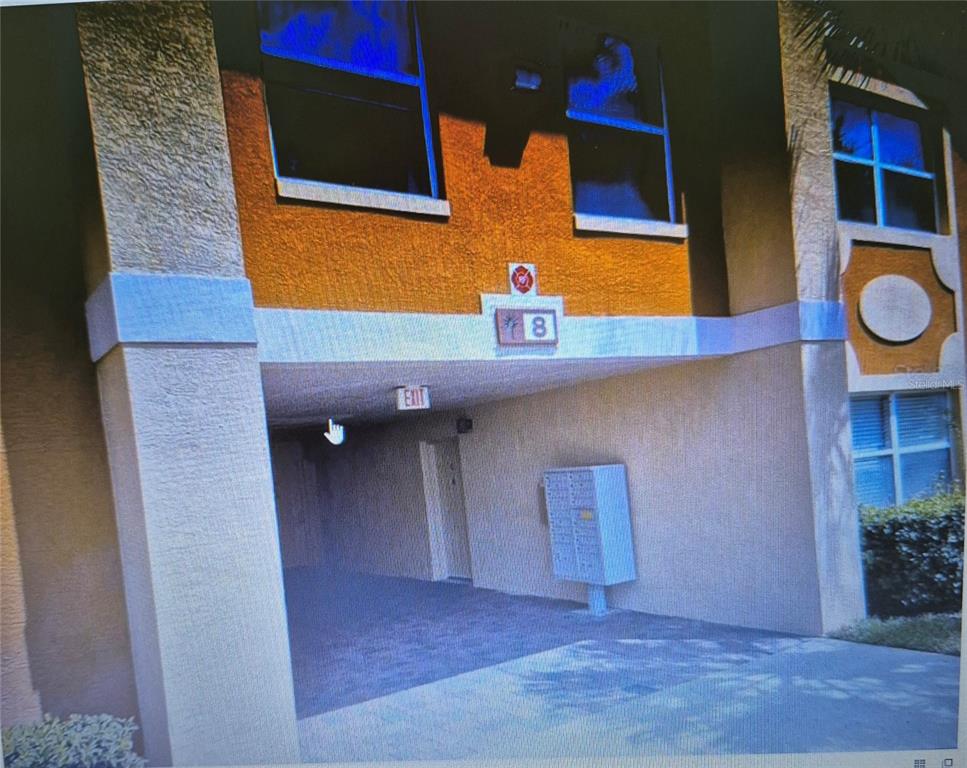 The exterior of a multi-story apartment building features a covered entryway with mailboxes — 4600 E MOODY BOULEVARD UNIT 8B, BUNNELL, FL