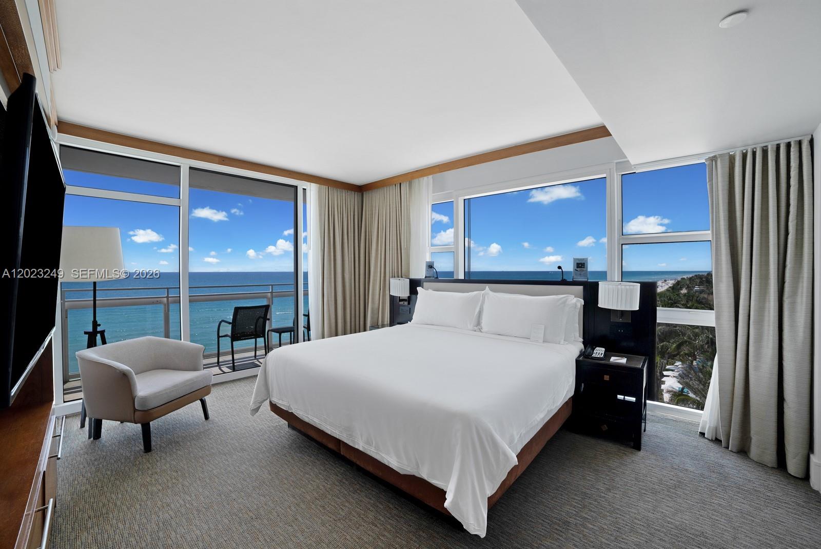 A hotel bedroom features a king bed, floor-to-ceiling windows, and a private oceanfront balcony — 6801 Collins Ave, Miami Beach FL 33141, MIAMI BEACH, FL