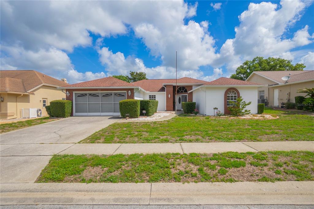 A single-story house with a white exterior, a two-car garage, and a brown roof — 3943 W FIELDWOOD COURT, LECANTO, FL