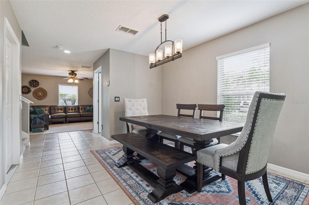 A dining area features a dark wood table with a bench and upholstered chairs — 657 PREAKNESS CIRCLE, DELAND, FL