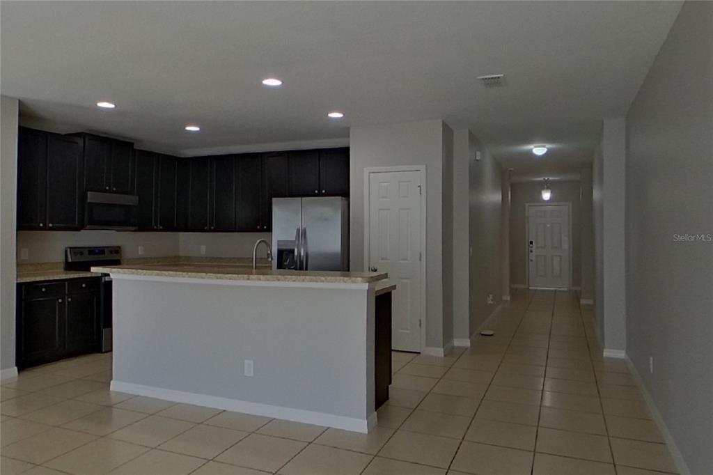 A kitchen with dark cabinets, stainless steel appliances, and a breakfast bar island — 2800 GLENDIVE DRIVE, KISSIMMEE, FL