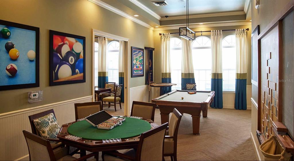 A game room features a poker table, a pool table, and wall-mounted artwork — 4 MAGGIE LANE UNIT Symphony, SARASOTA, FL