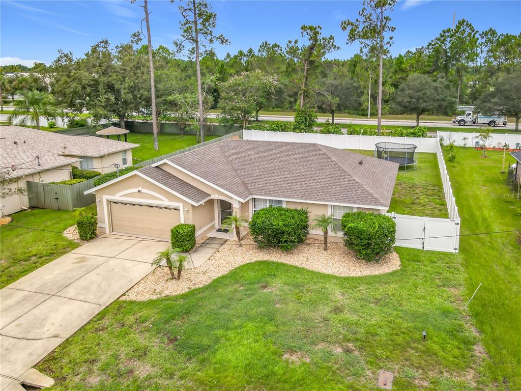 An aerial view of a single-story suburban house with a tan exterior and attached garage — 8 BAINBRIDGE LANE, PALM COAST, FL