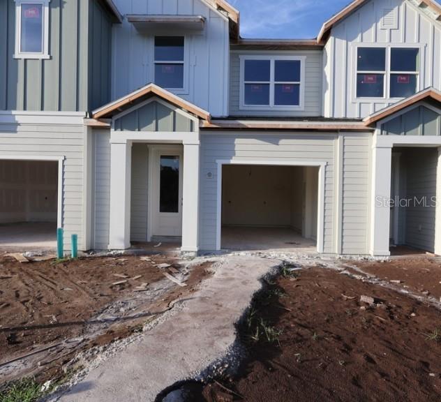 The exterior of a newly constructed townhouse featuring a garage and an unfinished front yard — 6355 JENSEN VIEW AVENUE, APOLLO BEACH, FL