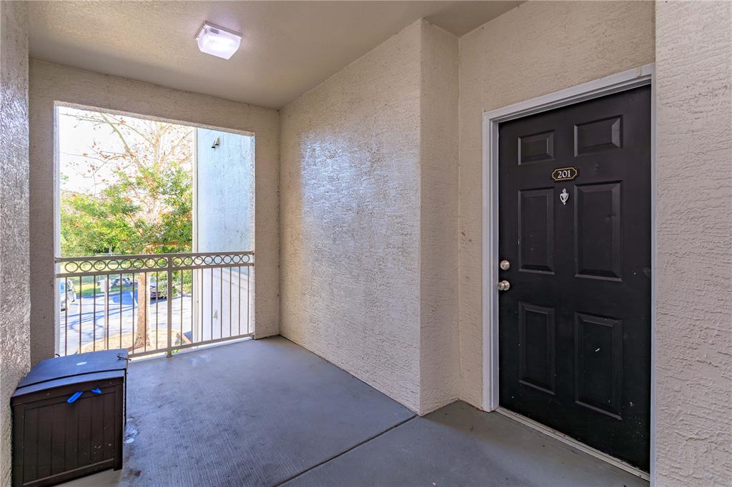 An exterior apartment entryway features a black door numbered 201 and a small balcony — 12849 MADISON POINT CIRCLE UNIT 201, ORLANDO, FL