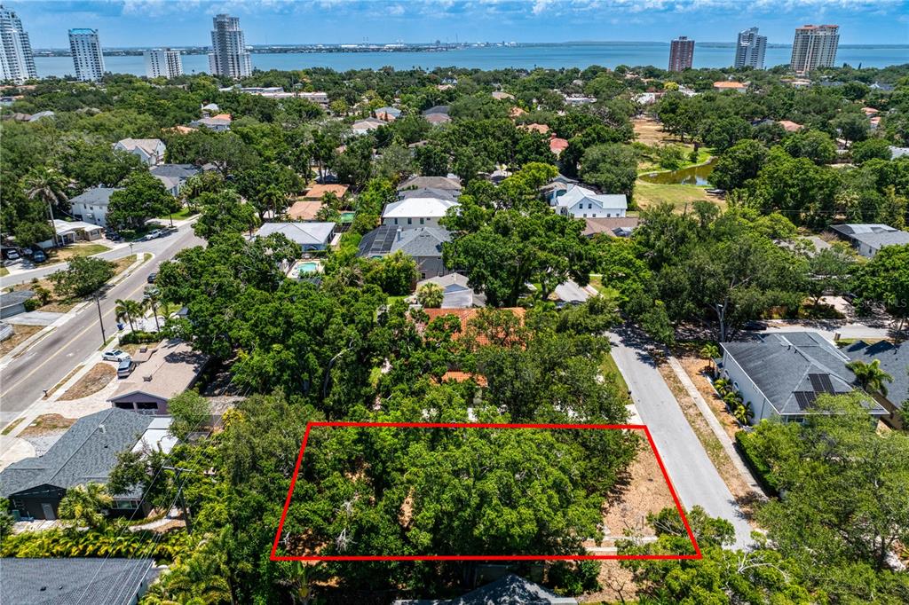 An aerial view shows a rectangular, tree-covered vacant lot outlined in red in a neighborhood — 3403 W BAY VILLA AVENUE, TAMPA, FL