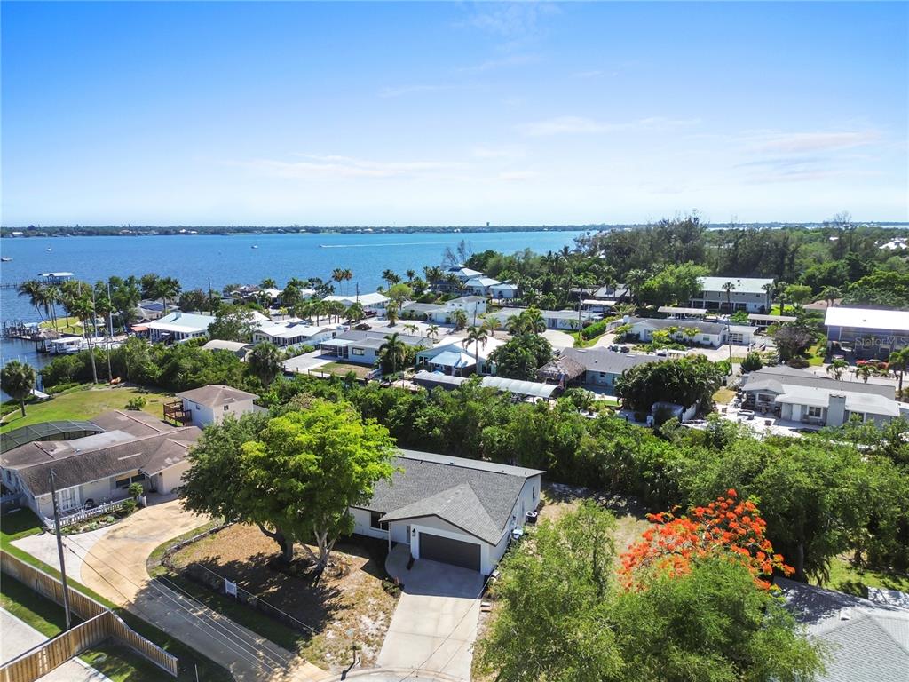 An aerial view shows a single-story house with a gray roof near a large body — 901 24TH AVENUE W, PALMETTO, FL