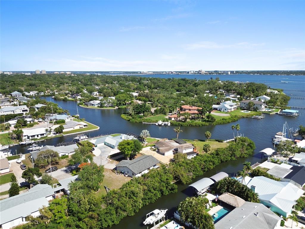 An aerial view shows waterfront houses along canals leading to a large bay — 901 24TH AVENUE W, PALMETTO, FL