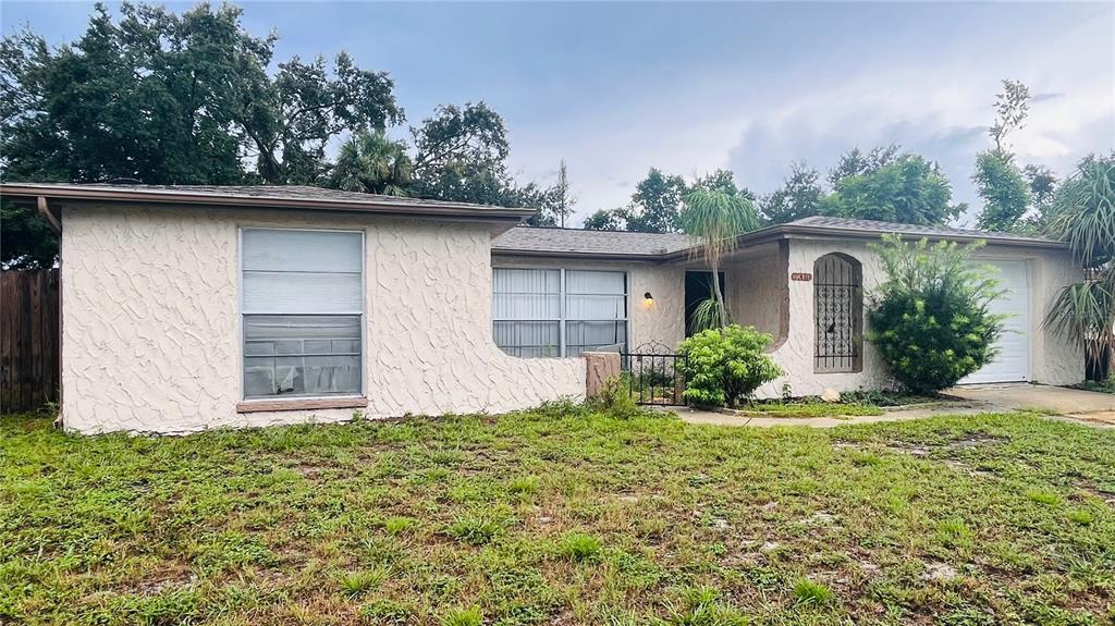 A single-story house with a stucco exterior, a front-facing window, and an attached garage — 7310 BRENTWOOD DRIVE, PORT RICHEY, FL