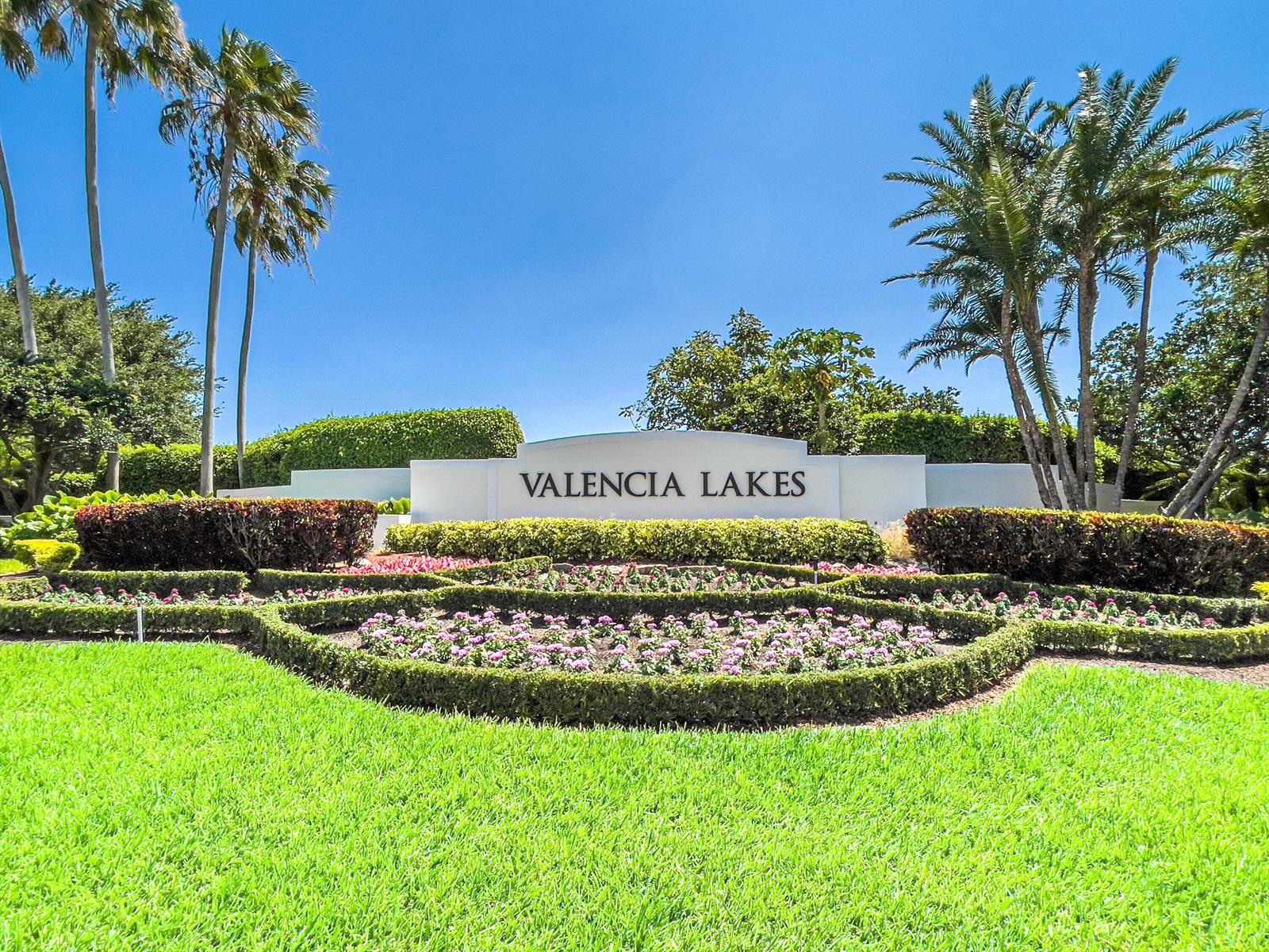 A white monument sign reading Valencia Lakes stands behind a manicured garden with palm trees — 11631 Puerto Boulevard, Boynton Beach FL 33437, BOYNTON BEACH, FL