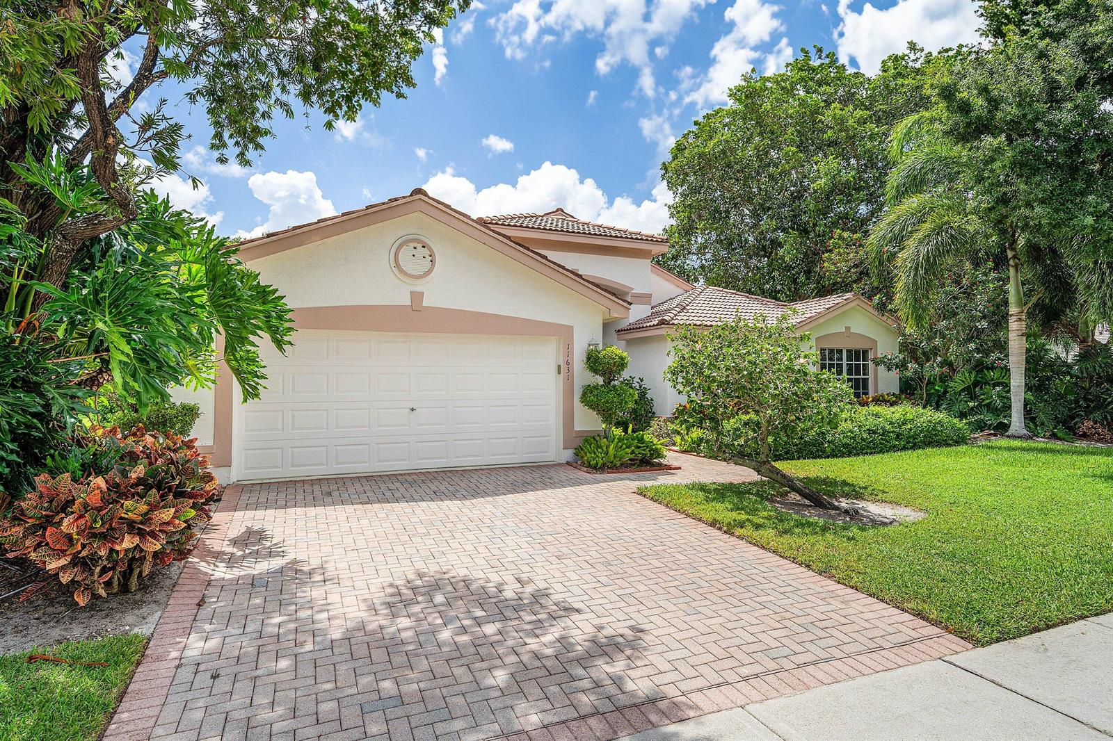 A single-story house with a white stucco facade, a two-car garage, and a paved driveway — 11631 Puerto Boulevard, Boynton Beach FL 33437, BOYNTON BEACH, FL