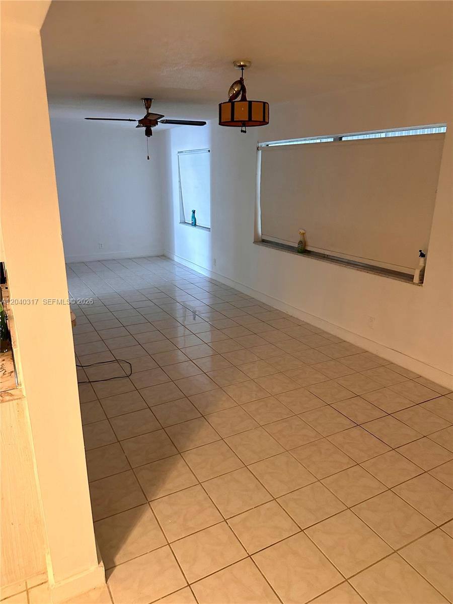 This room features light-colored tile flooring, a ceiling fan, and large windows with blinds — BOYNTON BEACH, FL