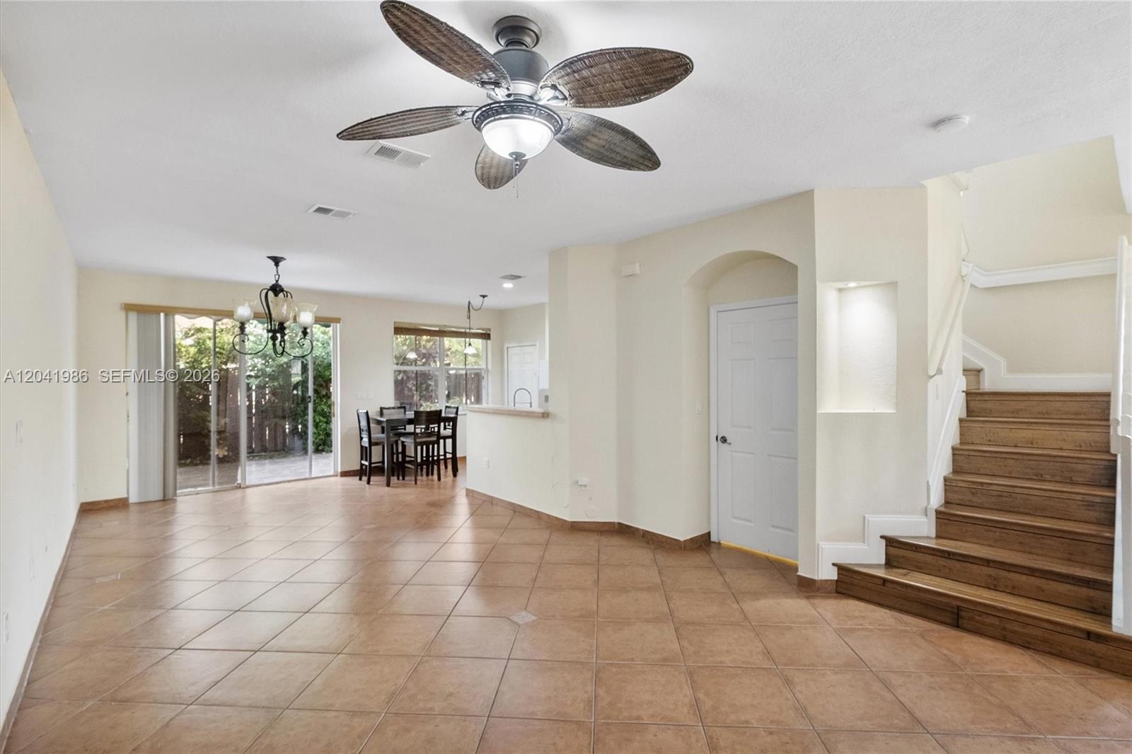 An open-concept living area features tile flooring, a ceiling fan, and a wooden staircase — 12334 SW 124th Path, Miami FL 33186, MIAMI, FL
