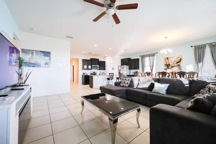 A living room with tile floors, a sectional sofa, and an open kitchen in back — 6078 BROAD OAK DRIVE, DAVENPORT, FL