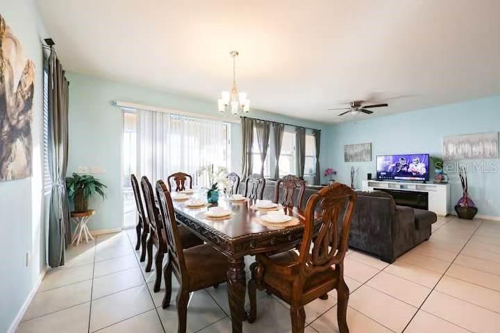 A dining area with a wooden table and chairs sits adjacent to a living room — 6078 BROAD OAK DRIVE, DAVENPORT, FL