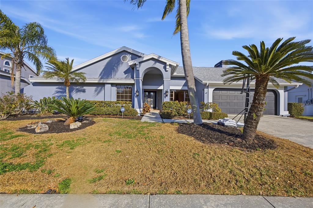 A single-story gray house with a two-car garage and palm trees in the front yard — 4157 SALTWATER BOULEVARD, TAMPA, FL