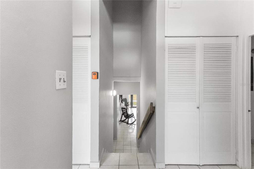 A view looking down a tiled staircase between two sets of white louvered closet doors — 227 BEACH VILLAGE UNIT 227, HUMACAO, PR
