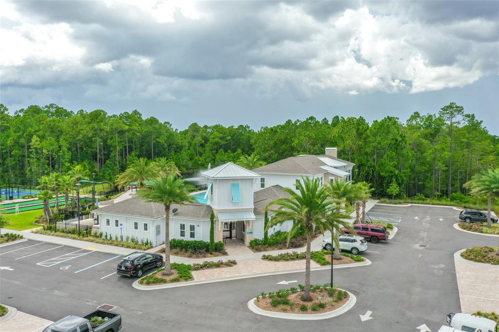 An aerial view shows a community clubhouse with a pool, parking lot, and surrounding trees — 16 PINNACLE PLACE, BUNNELL, FL