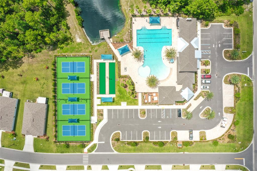 An aerial view shows a community recreation center with a swimming pool, tennis courts, and parking — 16 PINNACLE PLACE, BUNNELL, FL